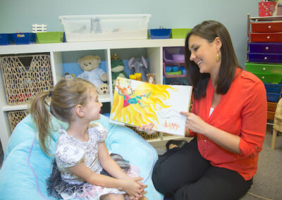 child-therapy Counselor Rachel Stewart in a play therapy session reading to child.