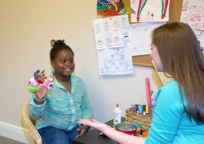_LS_1526 Therapist and child in play therapy session engaging with puppets