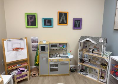 IMG_8342 Fort Myers Florida Play Therapy Room at the Fort Myers location, an easel, play kitchen, and doll house