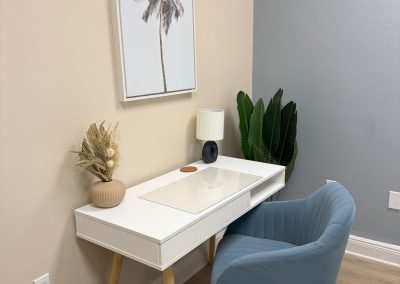 Small white desk and blue swivel chair